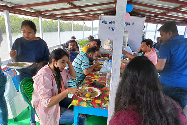 Tourists enjoying Bengali meal on Sundarban tour boat